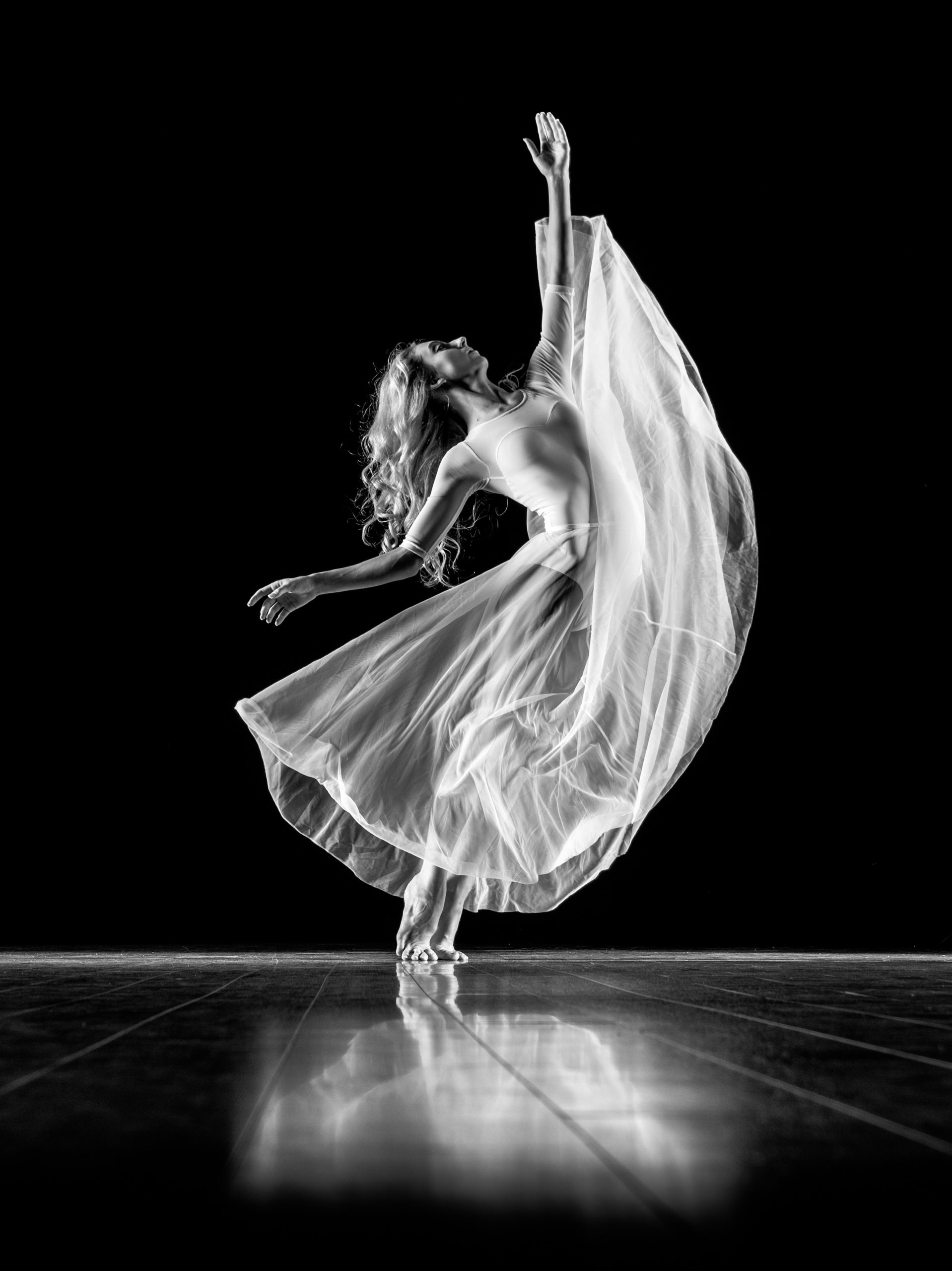 A ballet dancer with leg in full extension and a flowing skirt. 
