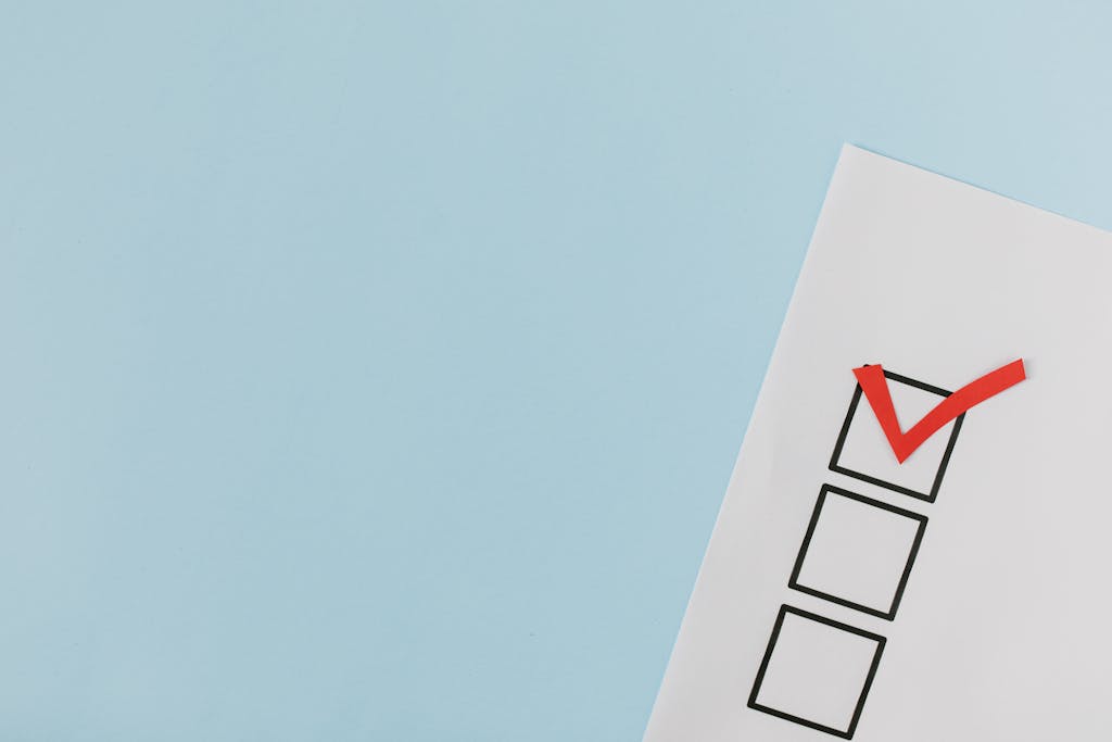 A checklist with a red checkmark symbolizing a completed task on a pastel blue background.