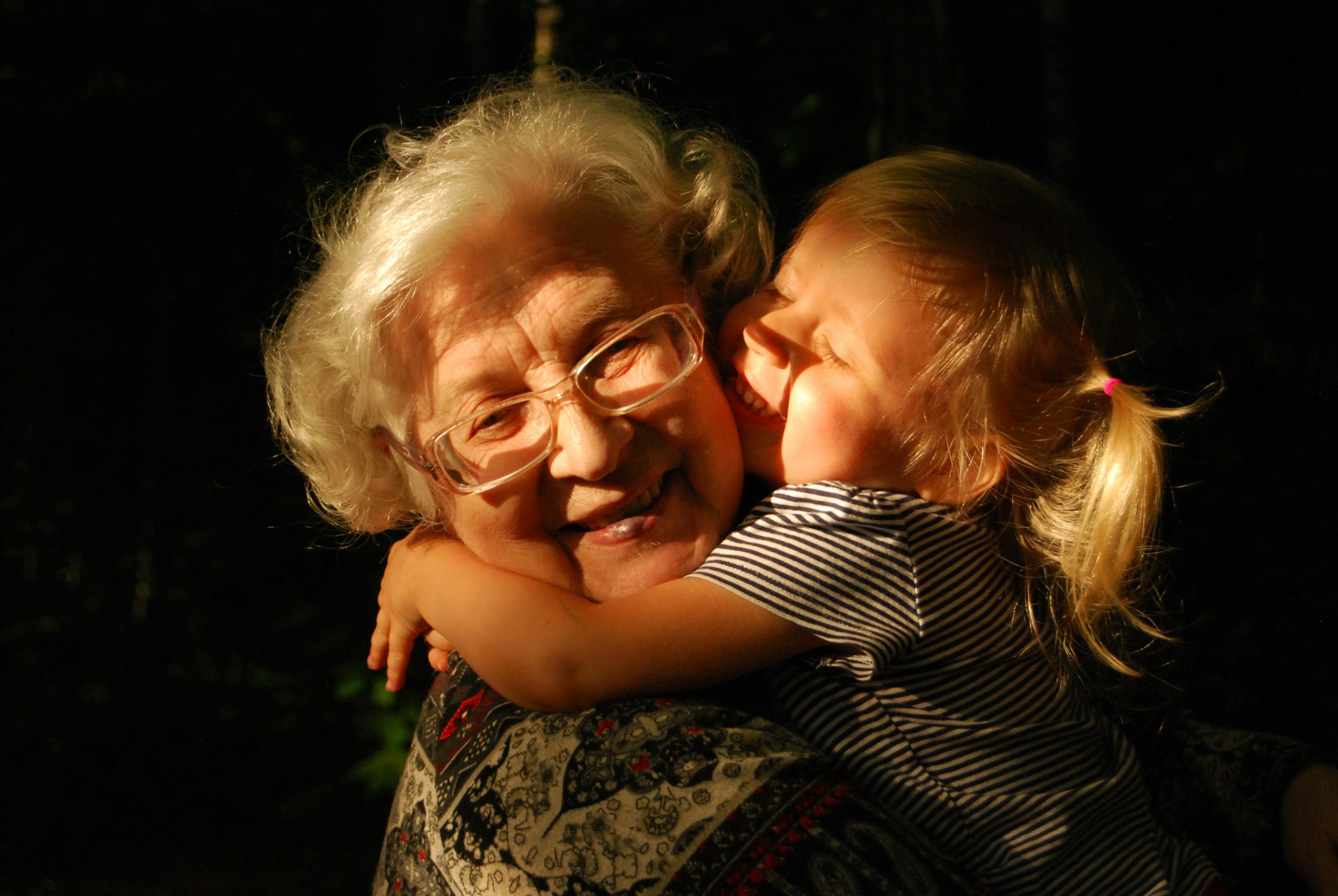 A smiling grandmother holding her granddaughter close