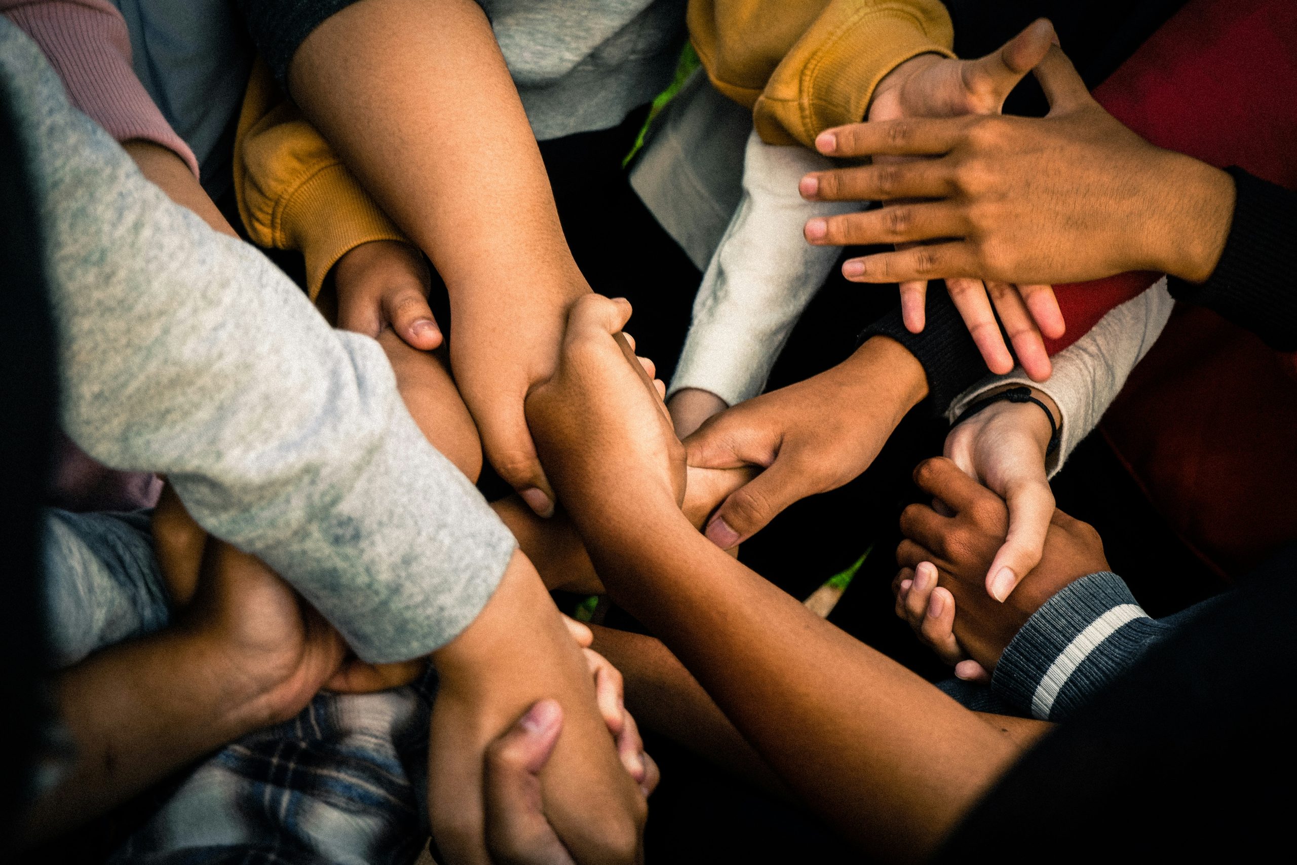 Many Hands crossing over each other to hold another hand